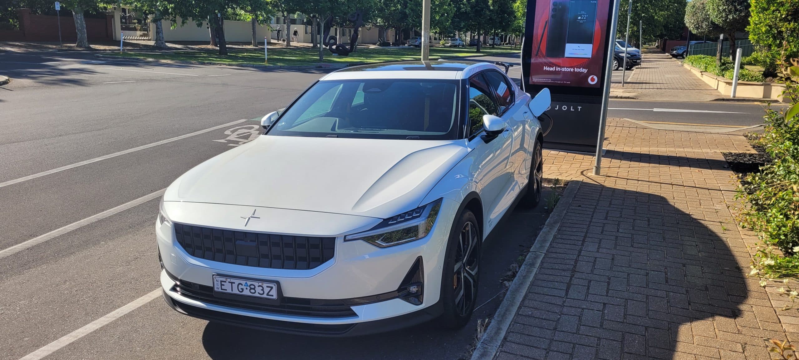 Snow coloured Polestar 2 dual motor EV with performance pack plugged into Jolt charging station