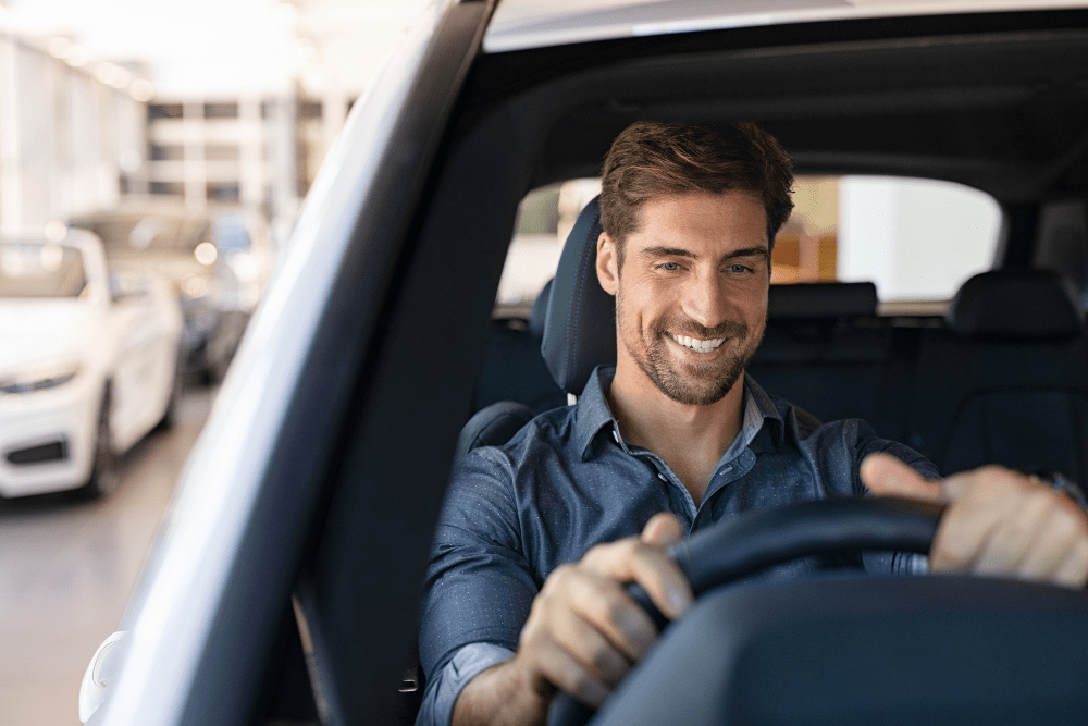 Smiling man driving his car
