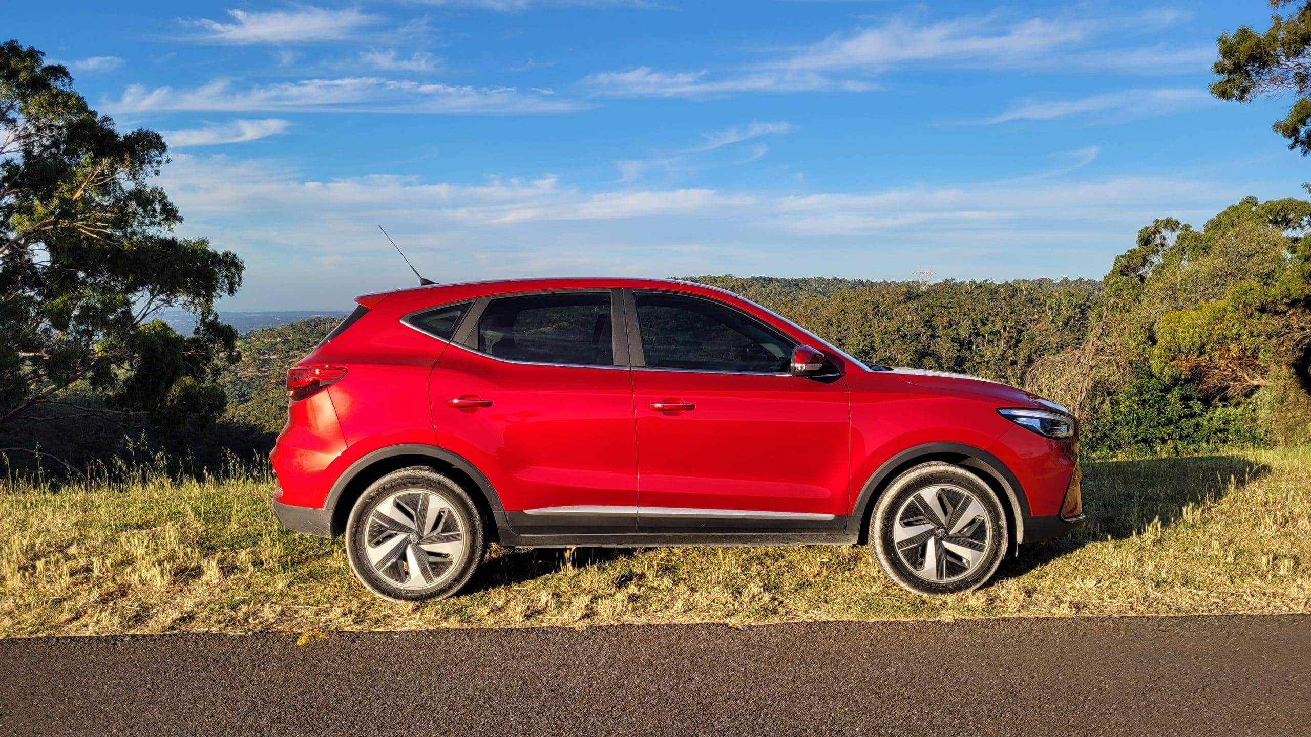 Red 2023 MG ZS EV parked on side of road