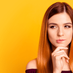 Personal Loans Banner - Young woman looks to the side while thinking against a yellow background