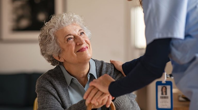 Older woman smiling at healthcare worker