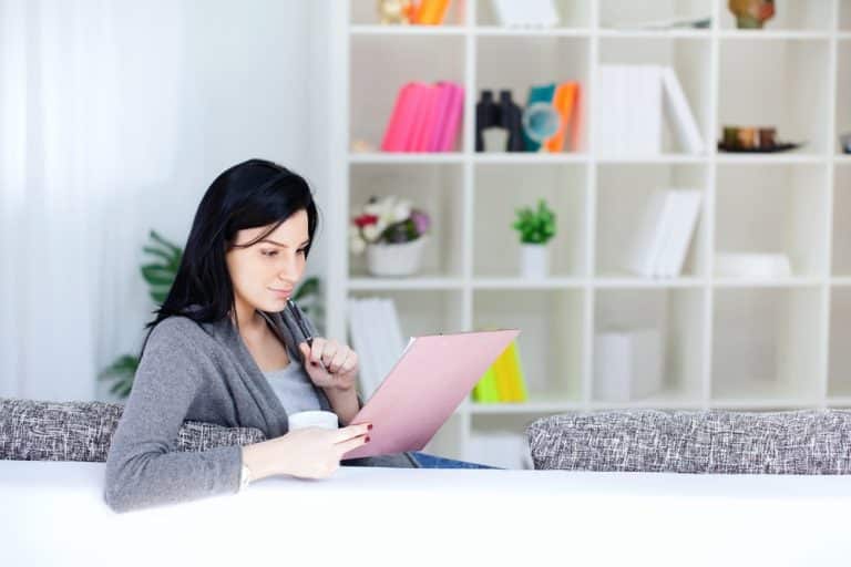 Health Insurance Banner - Young woman looking at health insurance documents at a desk