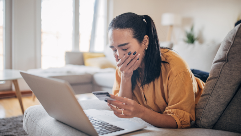 Australian woman using laptop worried she has been scammed