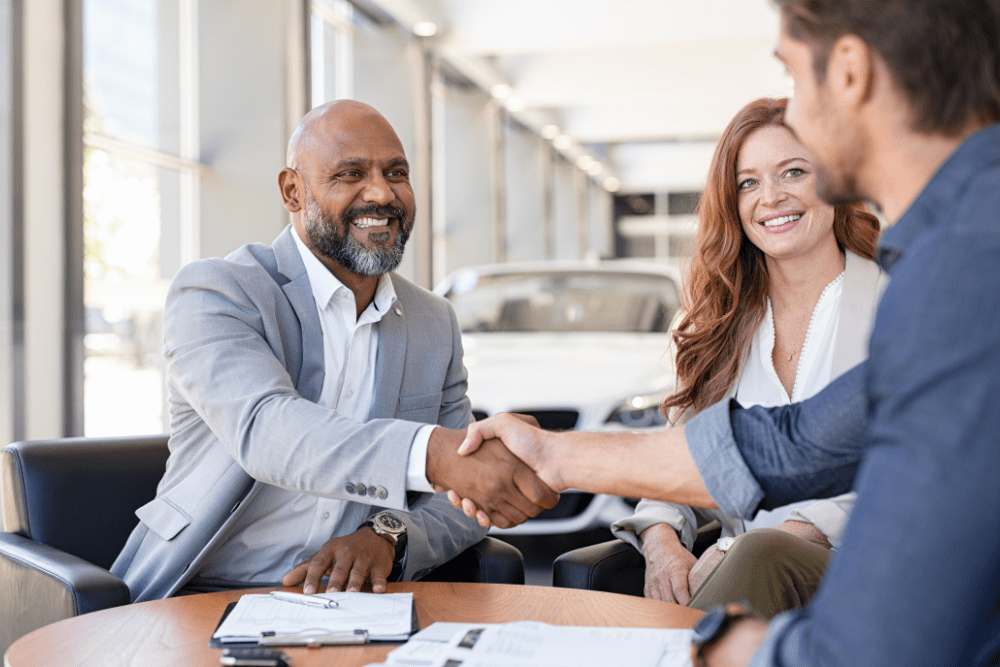 Car broker representative shaking hands with a new car buyer