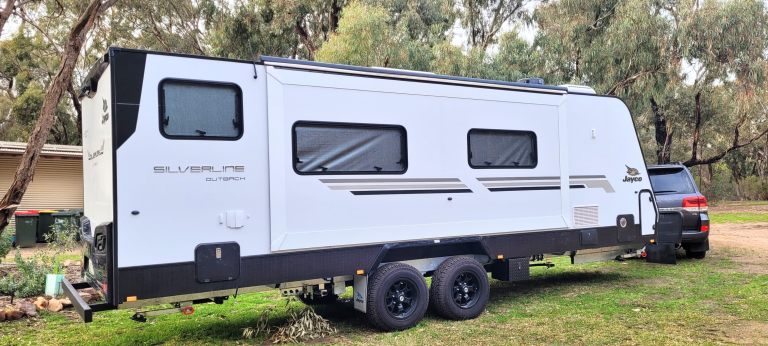 White Jayco Silverline Outback dual axle caravan hitched to 4WD