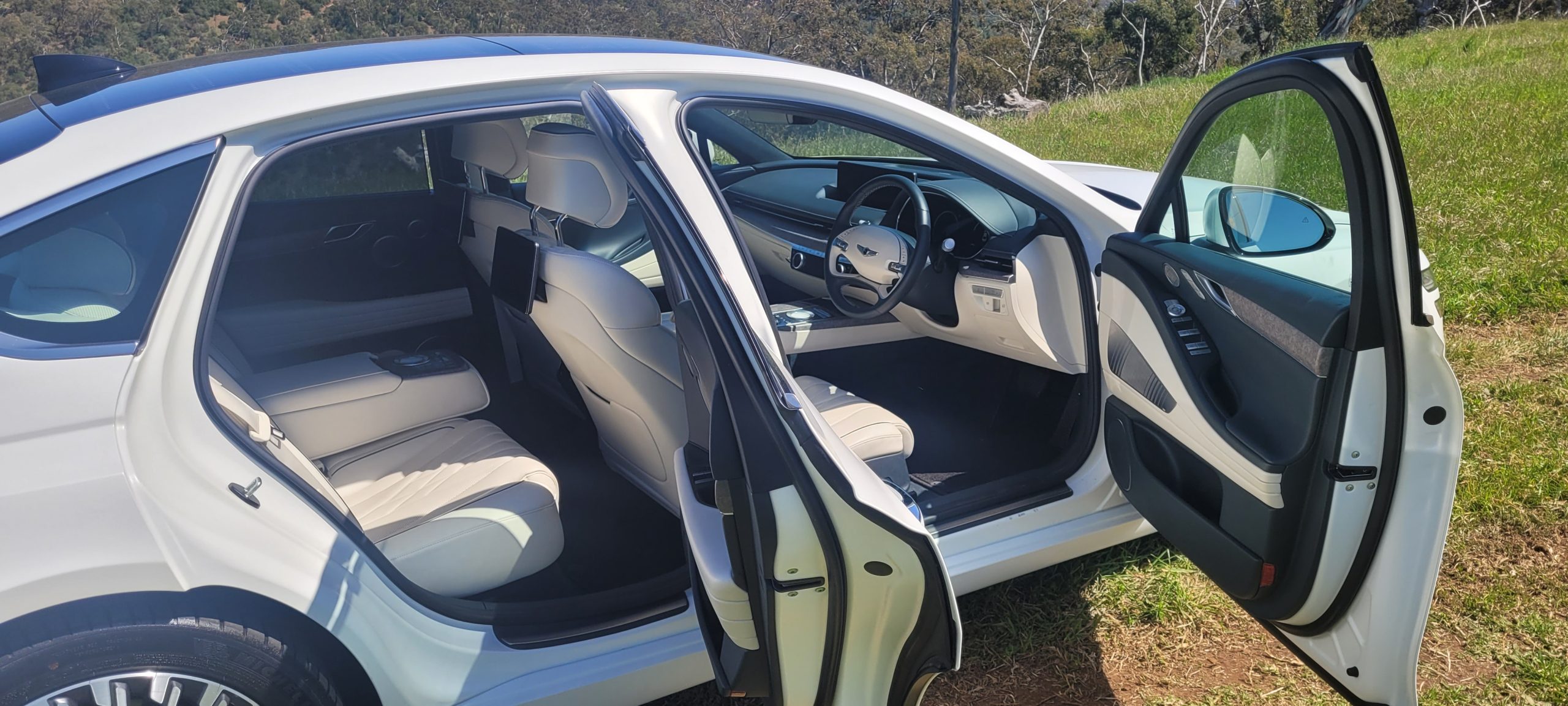 Matte White 2024 Genesis G80 EV side view with doors open.