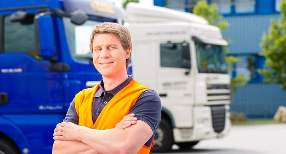 Man in high vis standing in front of trucks