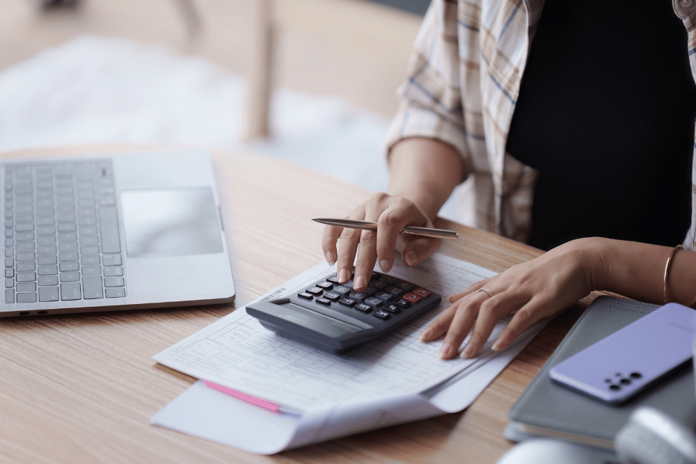 Person sitting at a desk calculating their bills