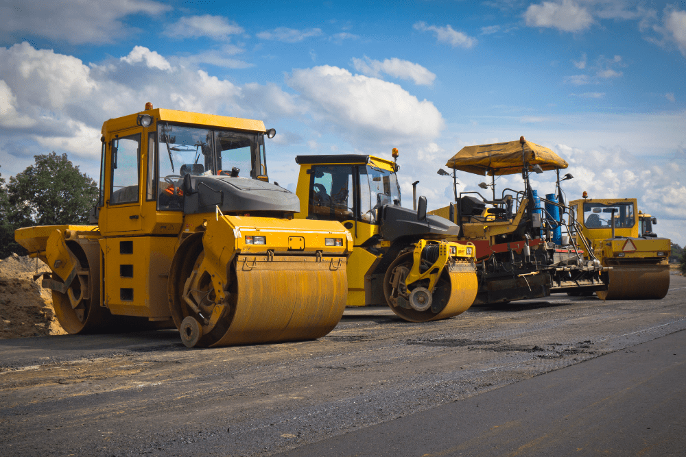 Road construction equipment lined up on a building site