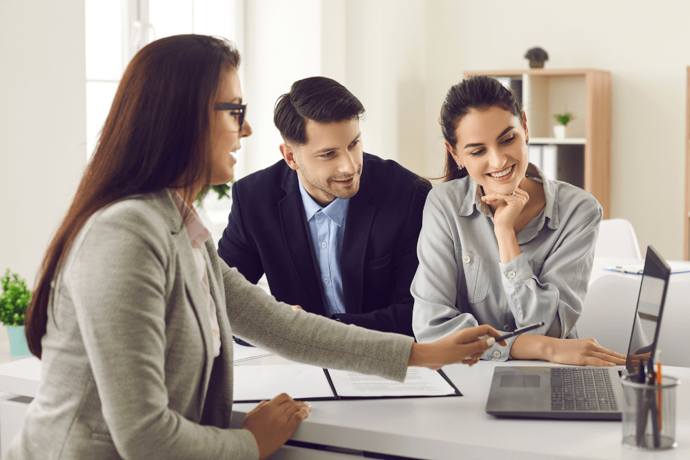 Couple looking at a laptop with a business representative