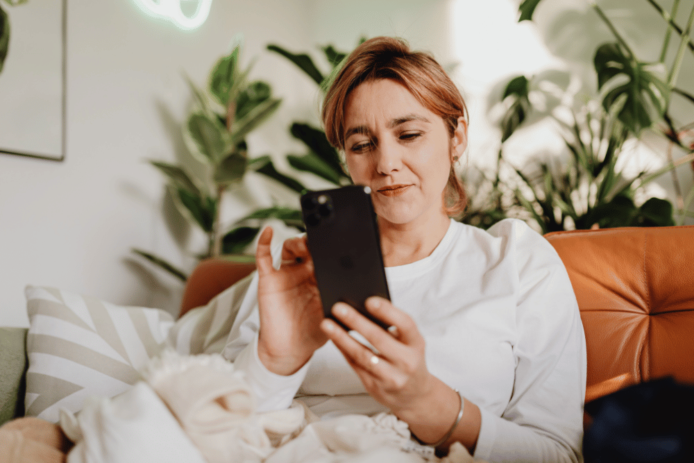 Woman sitting on the couch looking at her phone