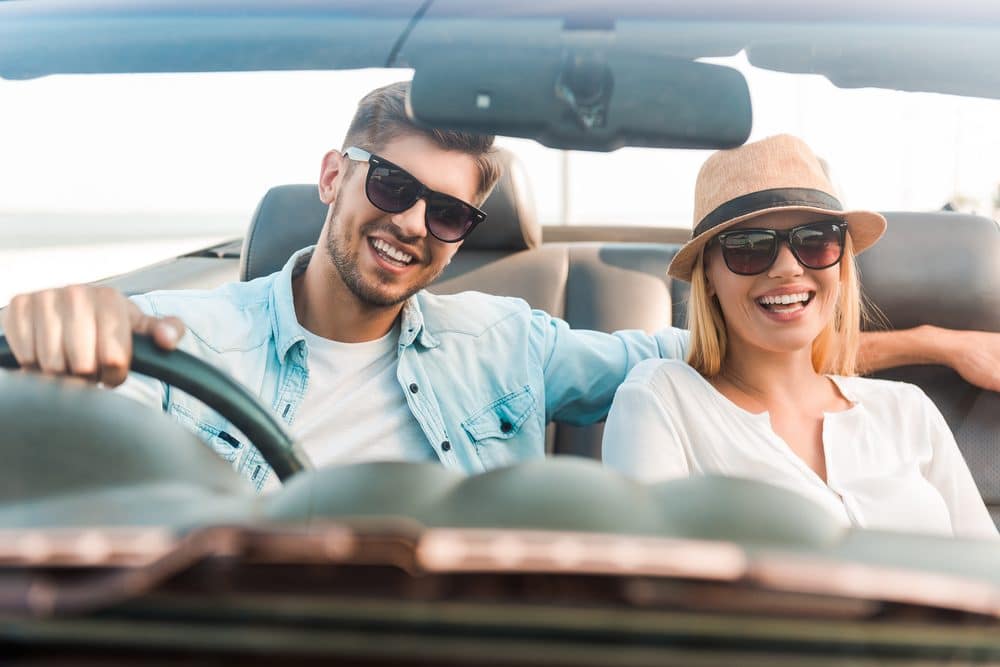 A driver and passenger enjoying their new car after bad credit car loan approval.