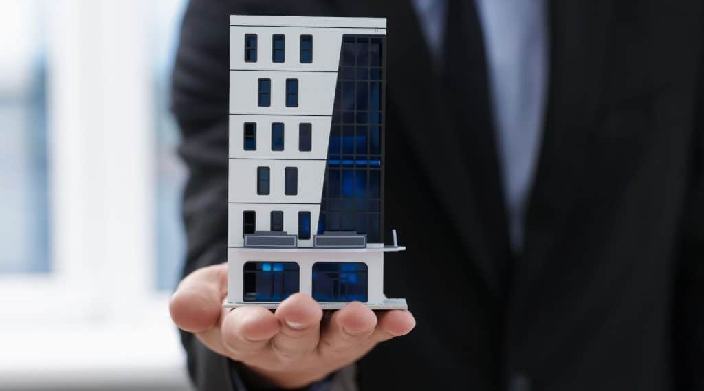 Man holding a model of a commercial office block