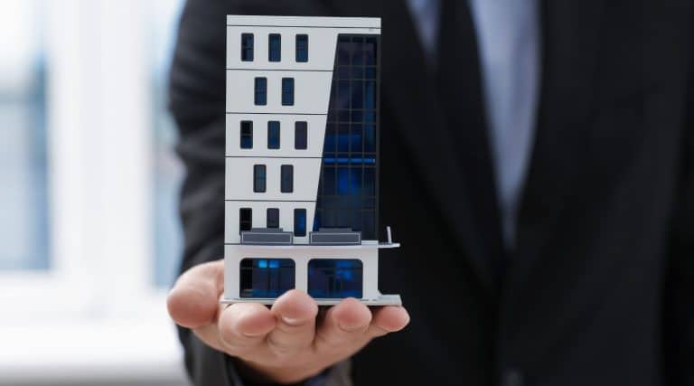 Man holding a model of a commercial office block