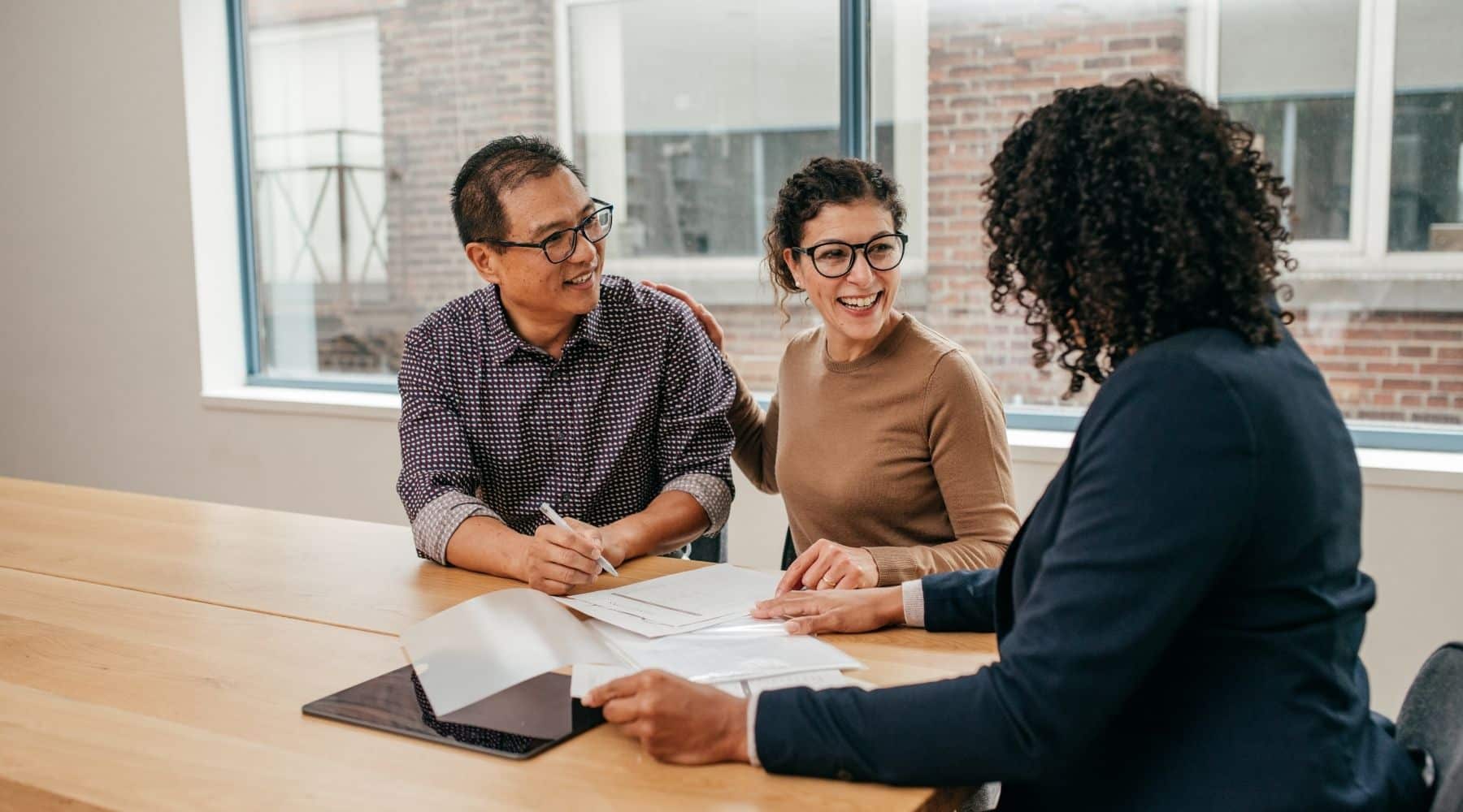 Couple meeting with agent to sign paperwork