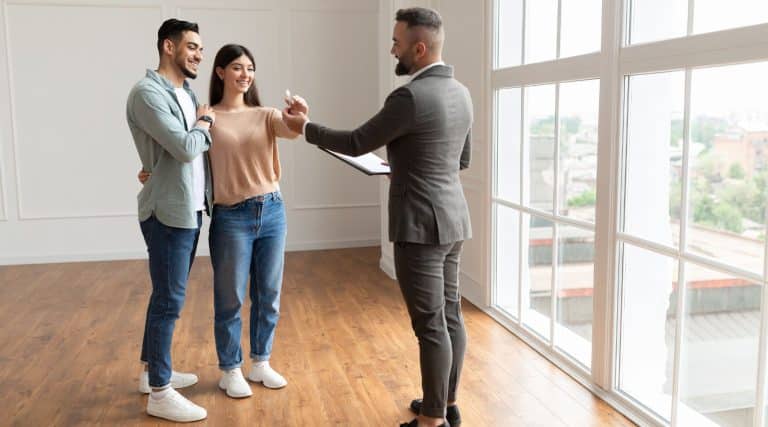 Young couple getting the keys to their home from the real estate agent