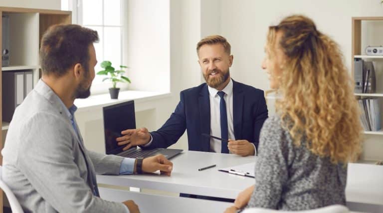 Mortgage broker speaking to a couple in his office