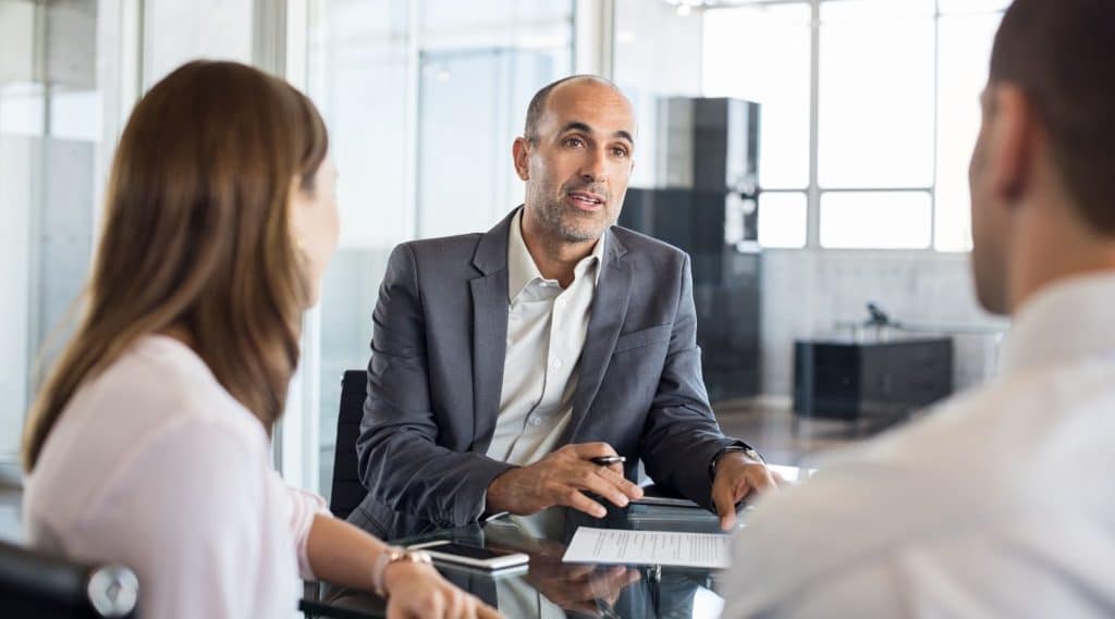 Banker speaking with a couple about their home loan