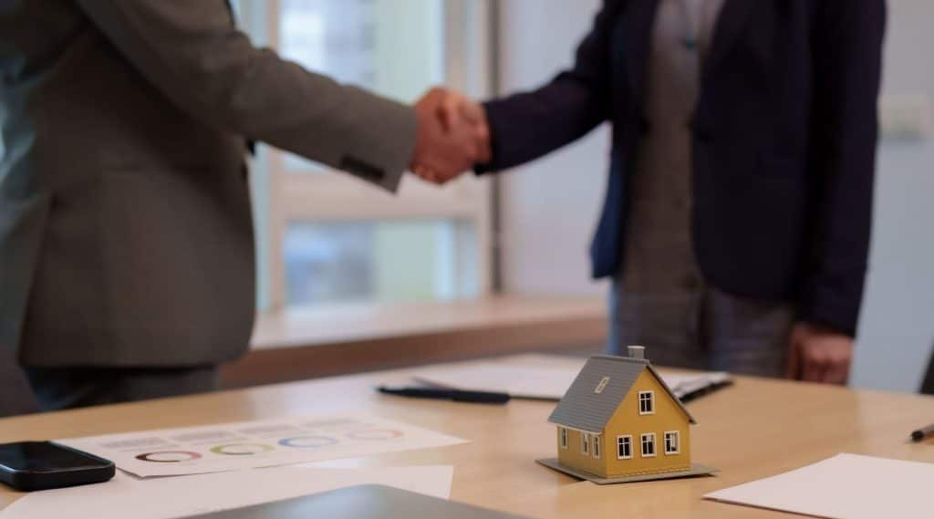 Two people shaking hands on a home loan deal