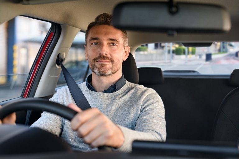 Man driving his car looking in rearview mirror