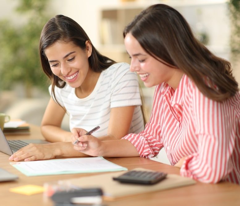 Two women signing a loan document