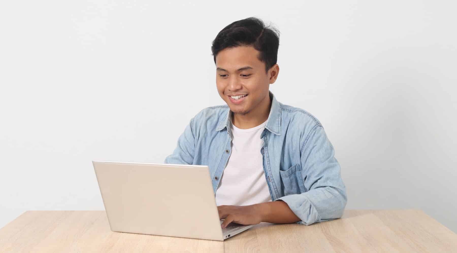 Man sitting at a table using his laptop