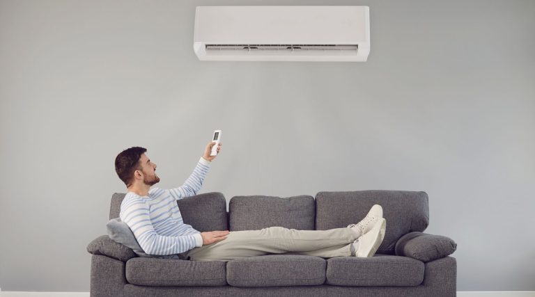 Man on the couch turning on air conditioner