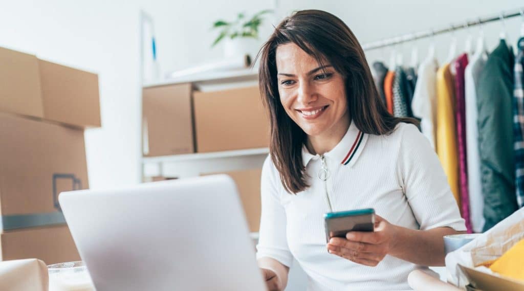 Small business owner using laptop and phone