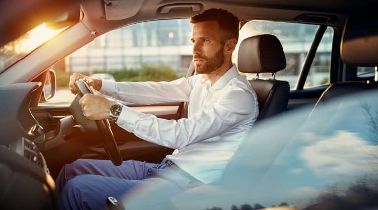 Man driving his car at sunset