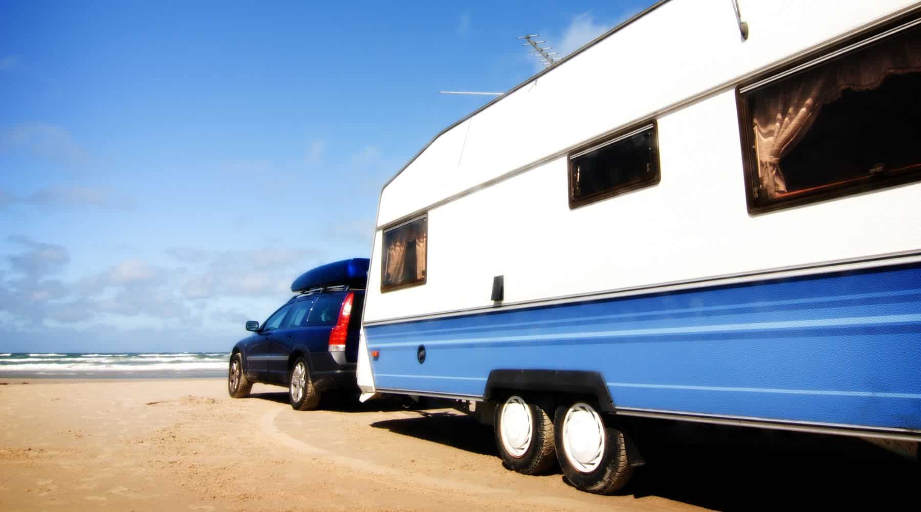 Car pulling caravan on the beach