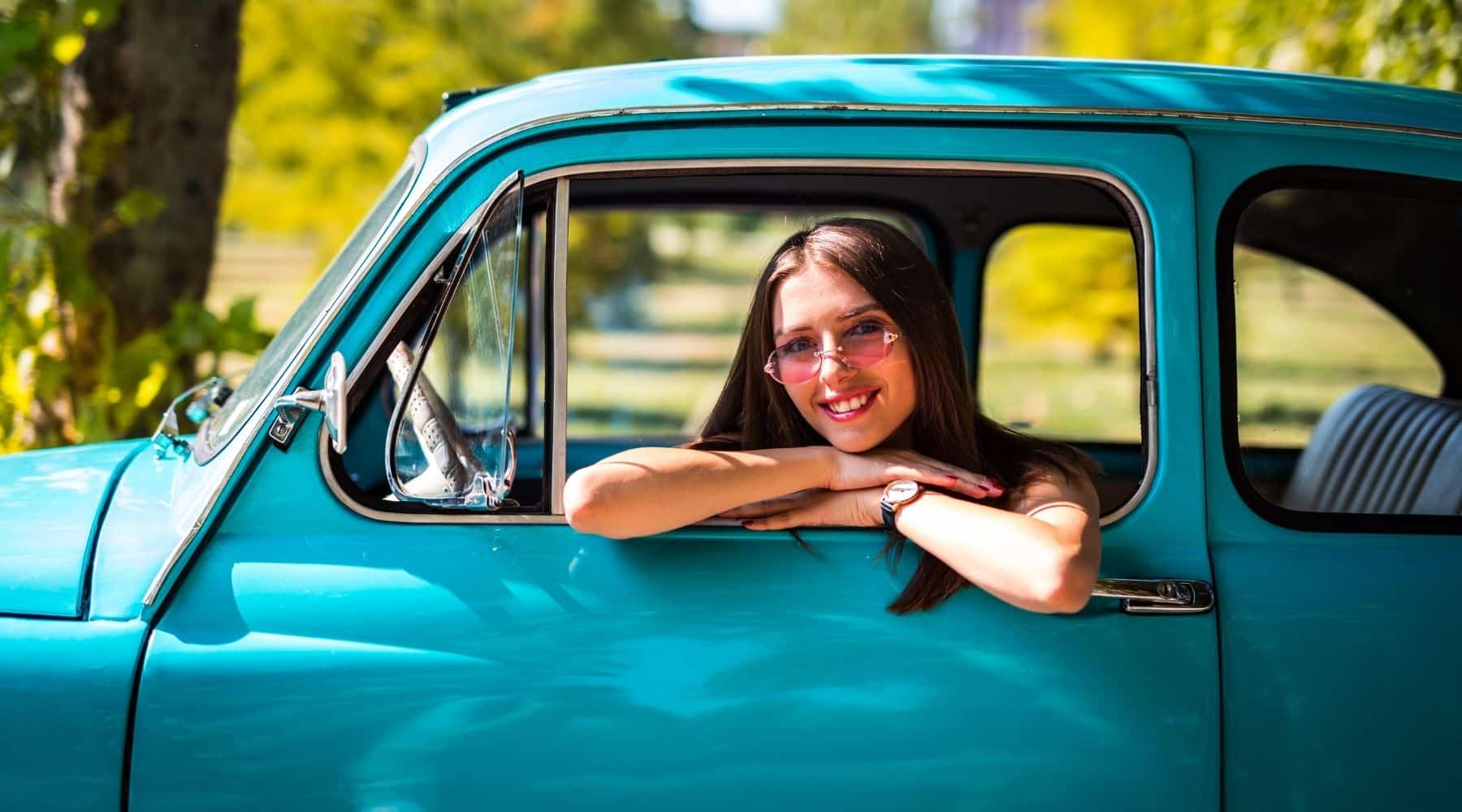 A woman sitting in a classic car