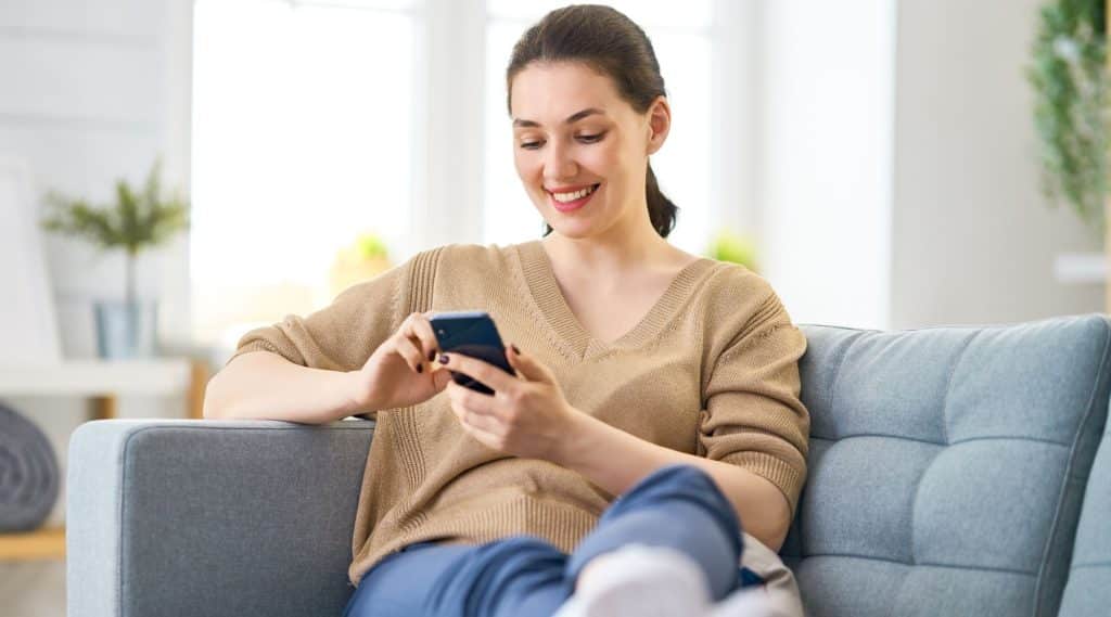 Woman looking at her phone on the couch