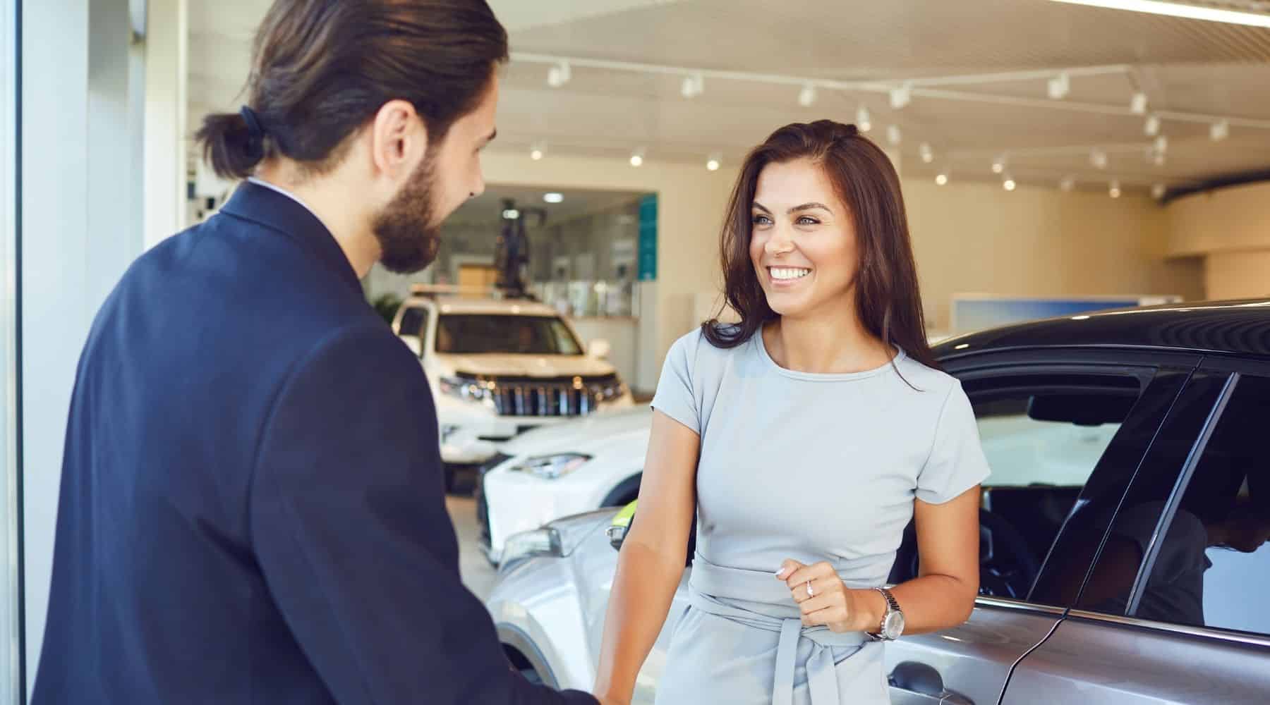 Woman shaking hands at car dealership