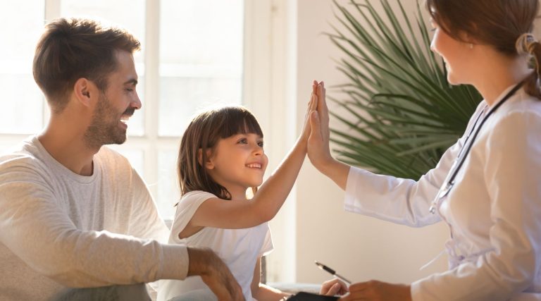Happy girl giving high five to doctor