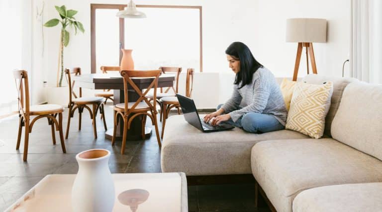 Woman sitting in her living room using a laptop