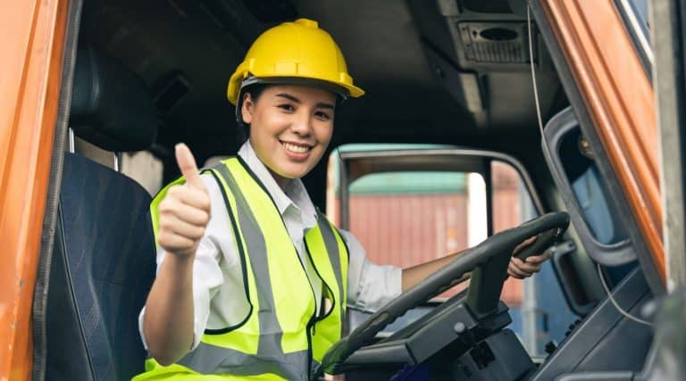 Person wearing hard hat behind the wheel of a truck