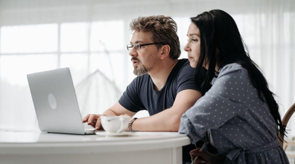 Couple sitting together looking at a laptop