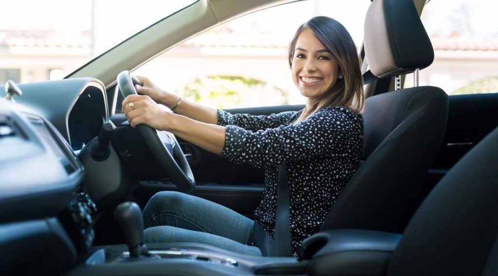 Smiling woman driving her car