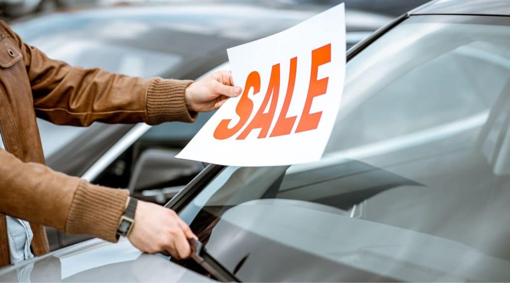 Sale sign being place on windshield of a new car