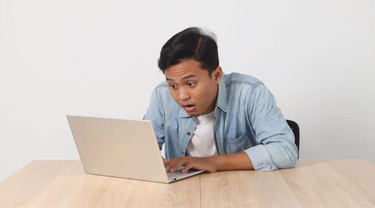 Surprised man looking at laptop
