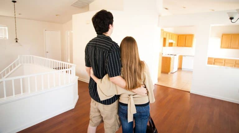 Young couple hugging and standing in their new home