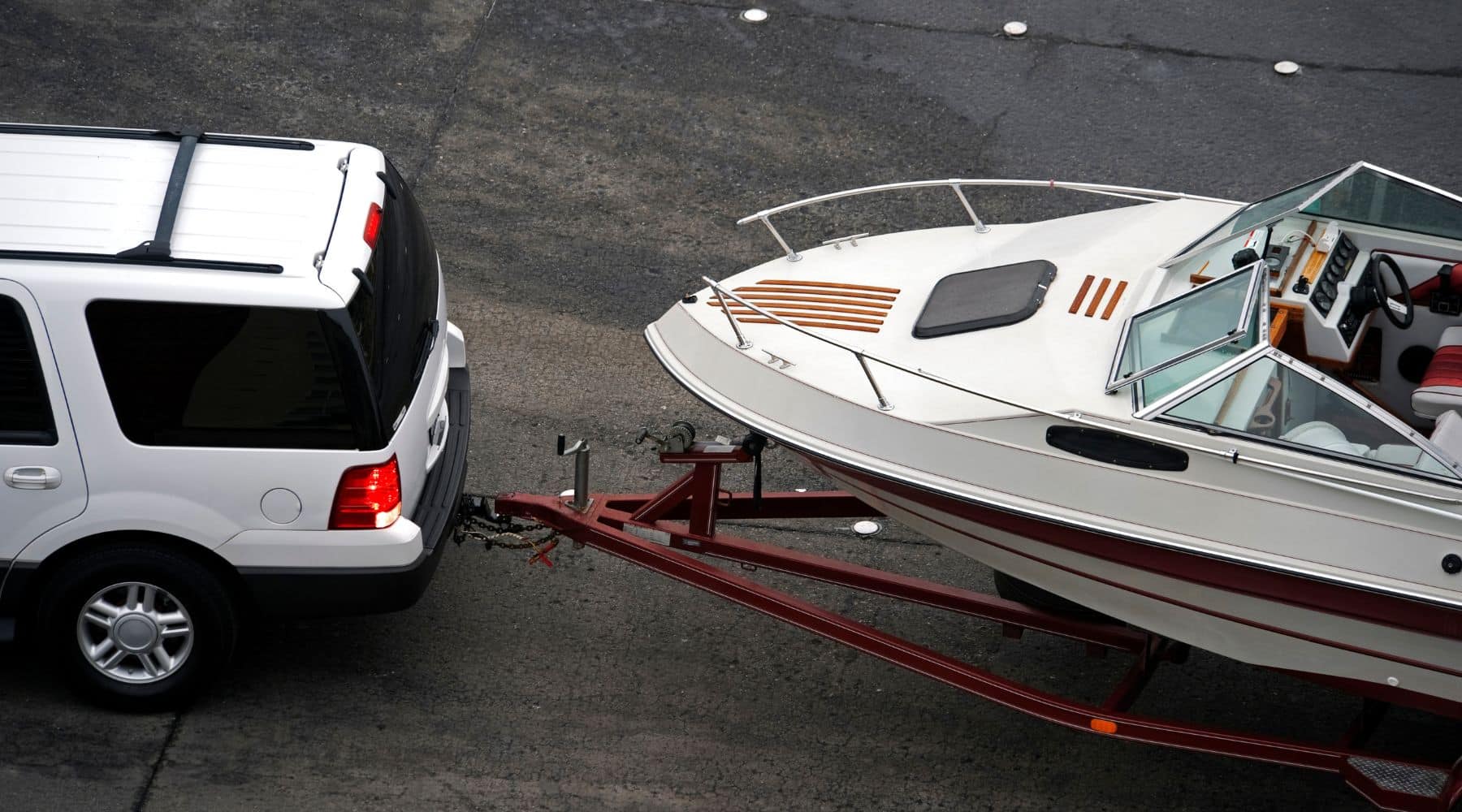 SUV reversing boat and trailer back on ramp