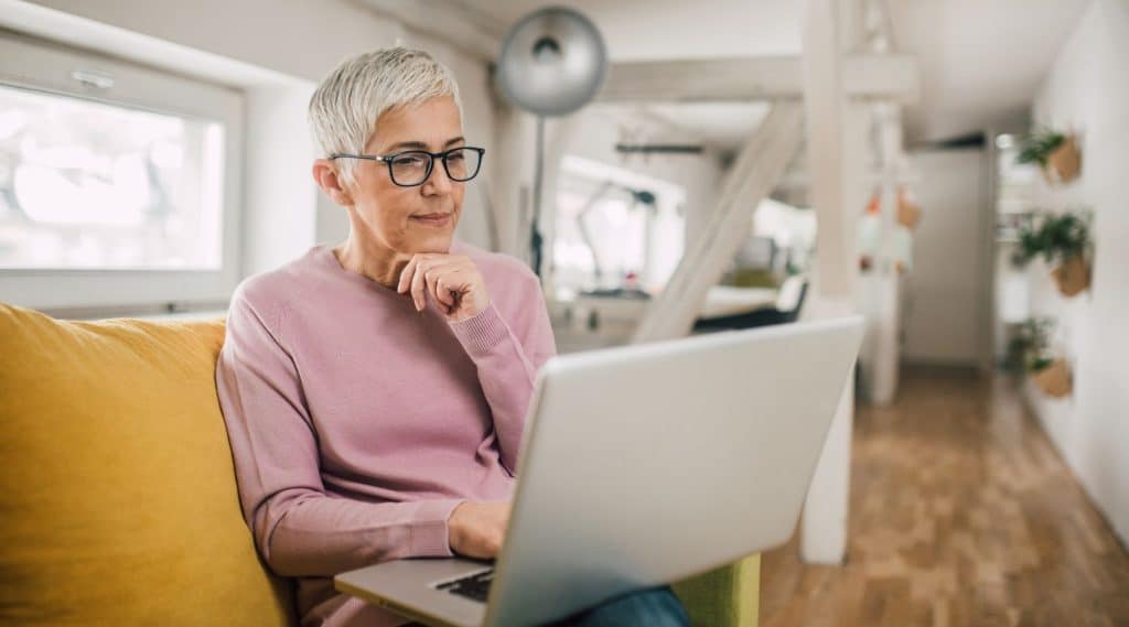 Woman looking at her laptop in her living room
