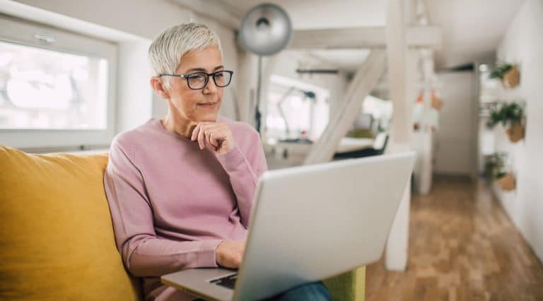 Woman looking at her laptop in her living room