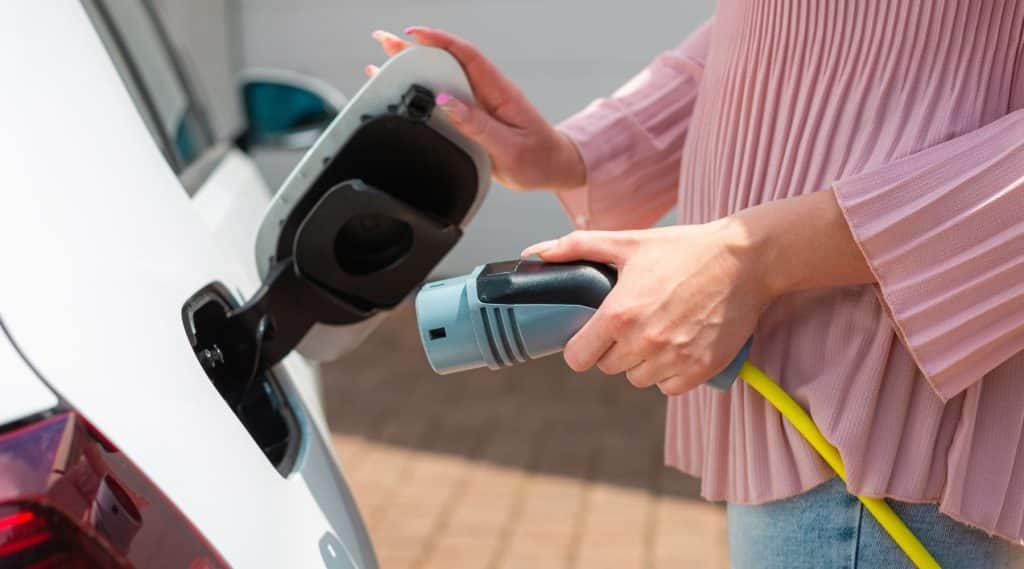 A woman charging her electric car at home