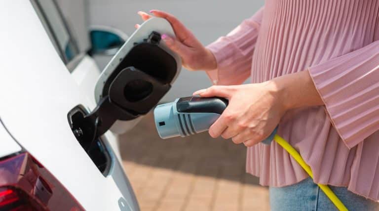 A woman charging her electric car at home