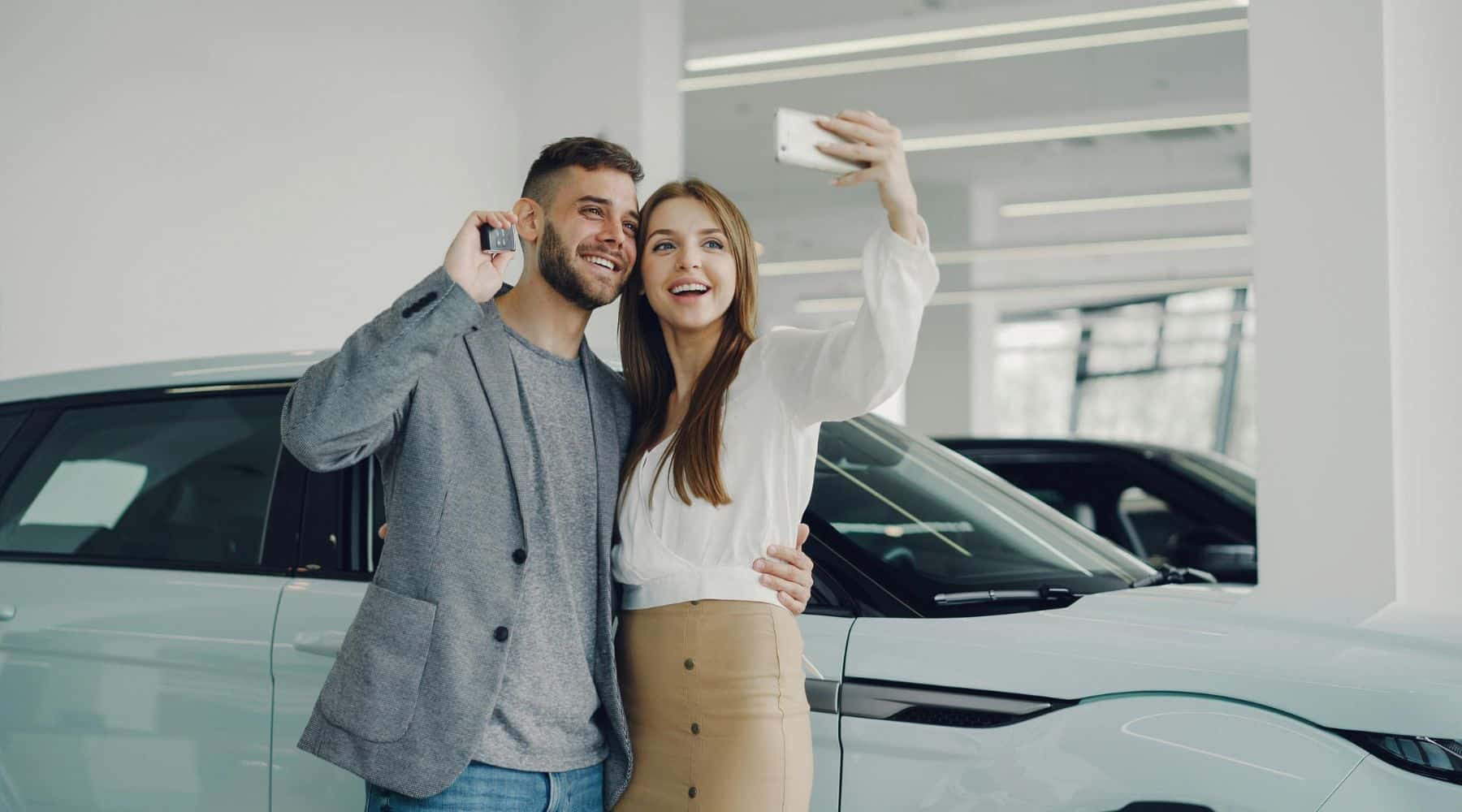 Couple taking selfie with new car purchase