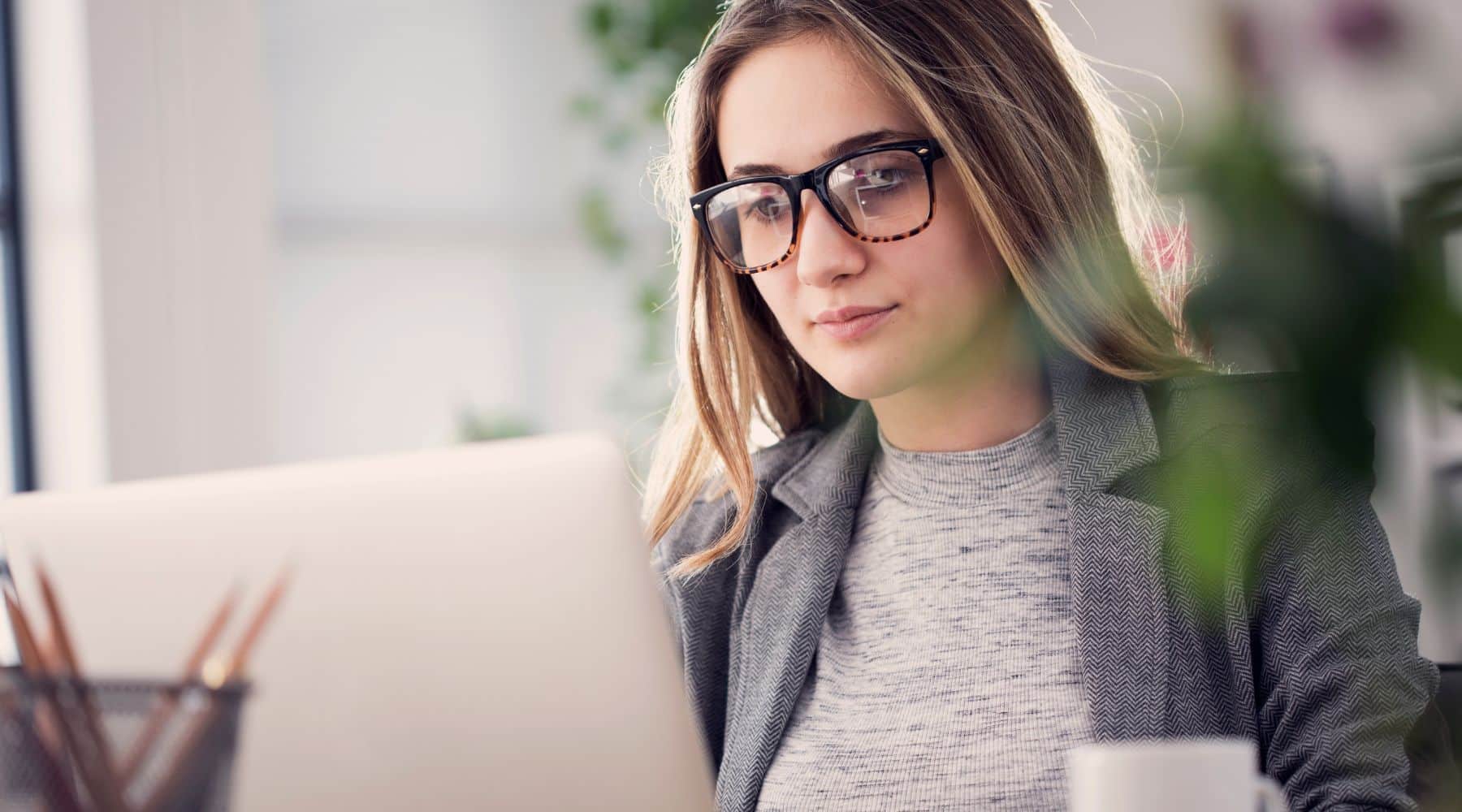 Woman in glasses working on her laptop