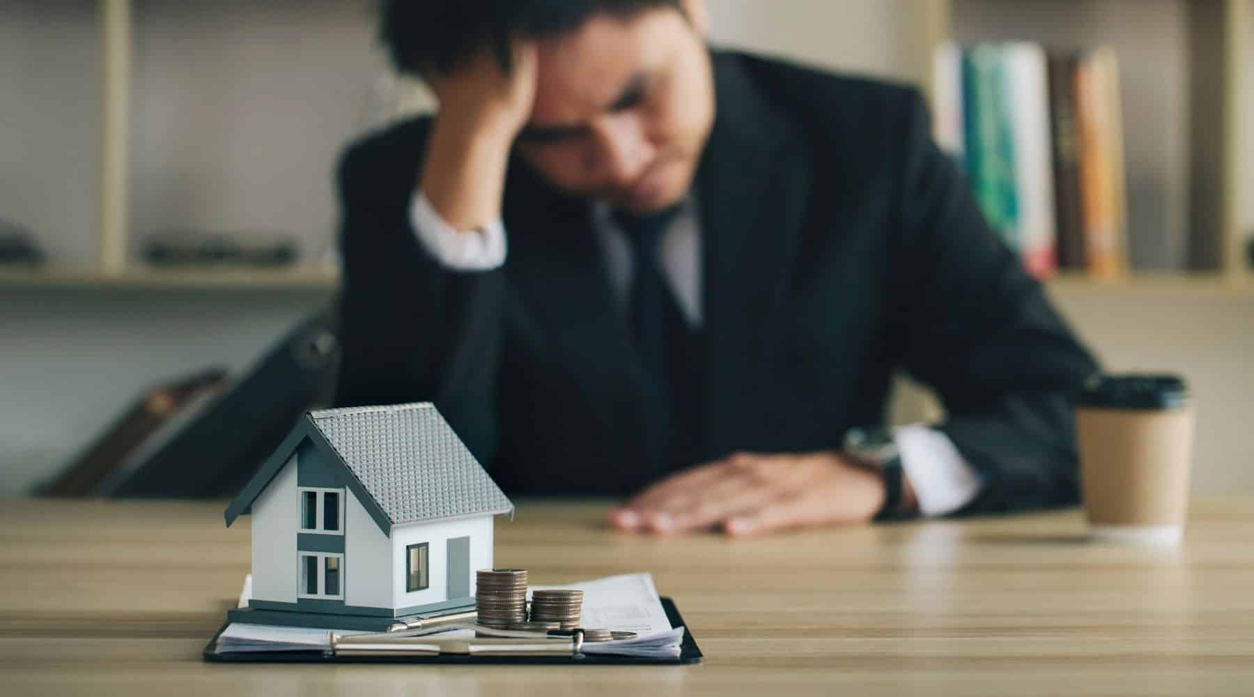 Stressed man with model home